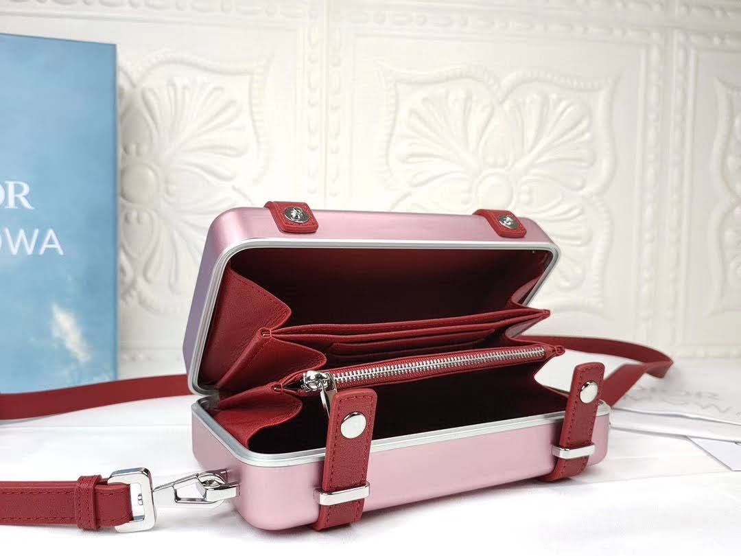 Presentation image of the opened pink Dior x Rimowa aluminum clutch inside details