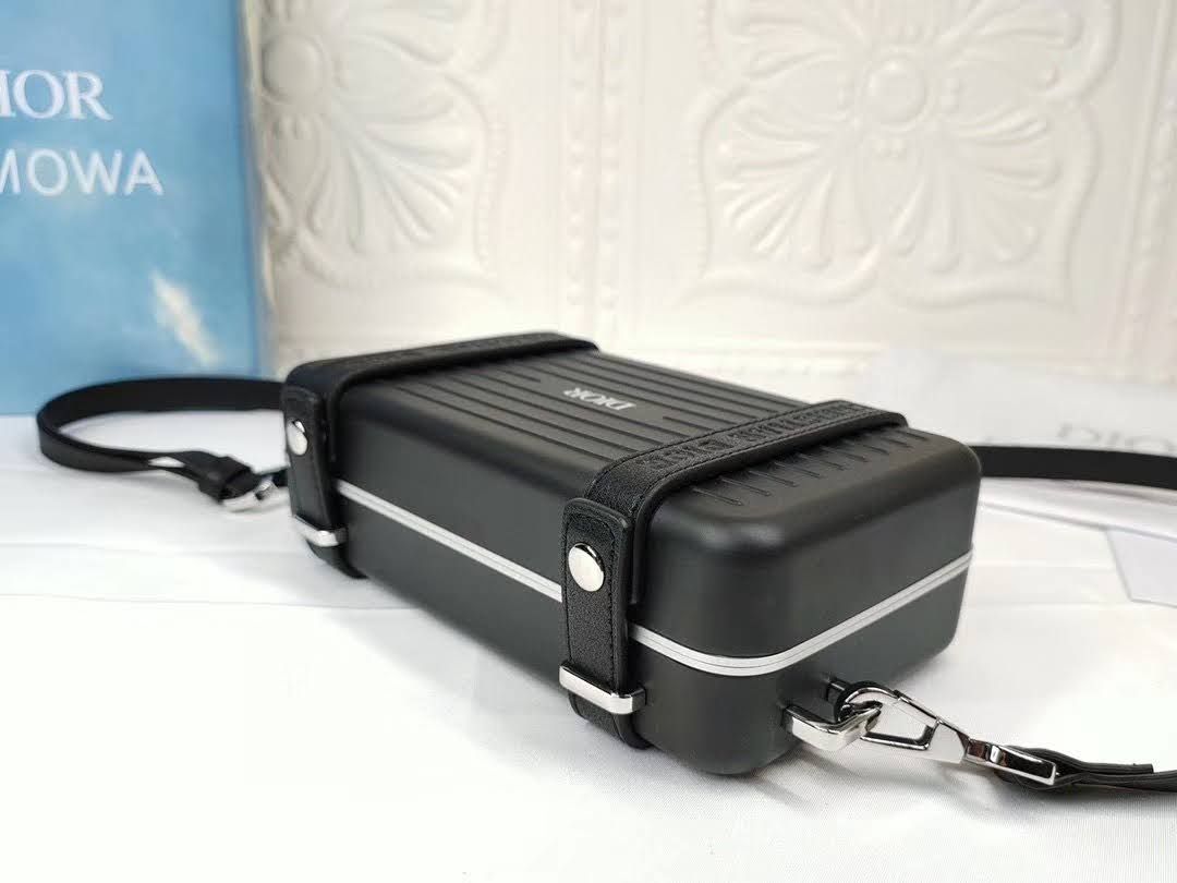 Presentation image of the black Dior x Rimowa aluminum clutch bottom feet