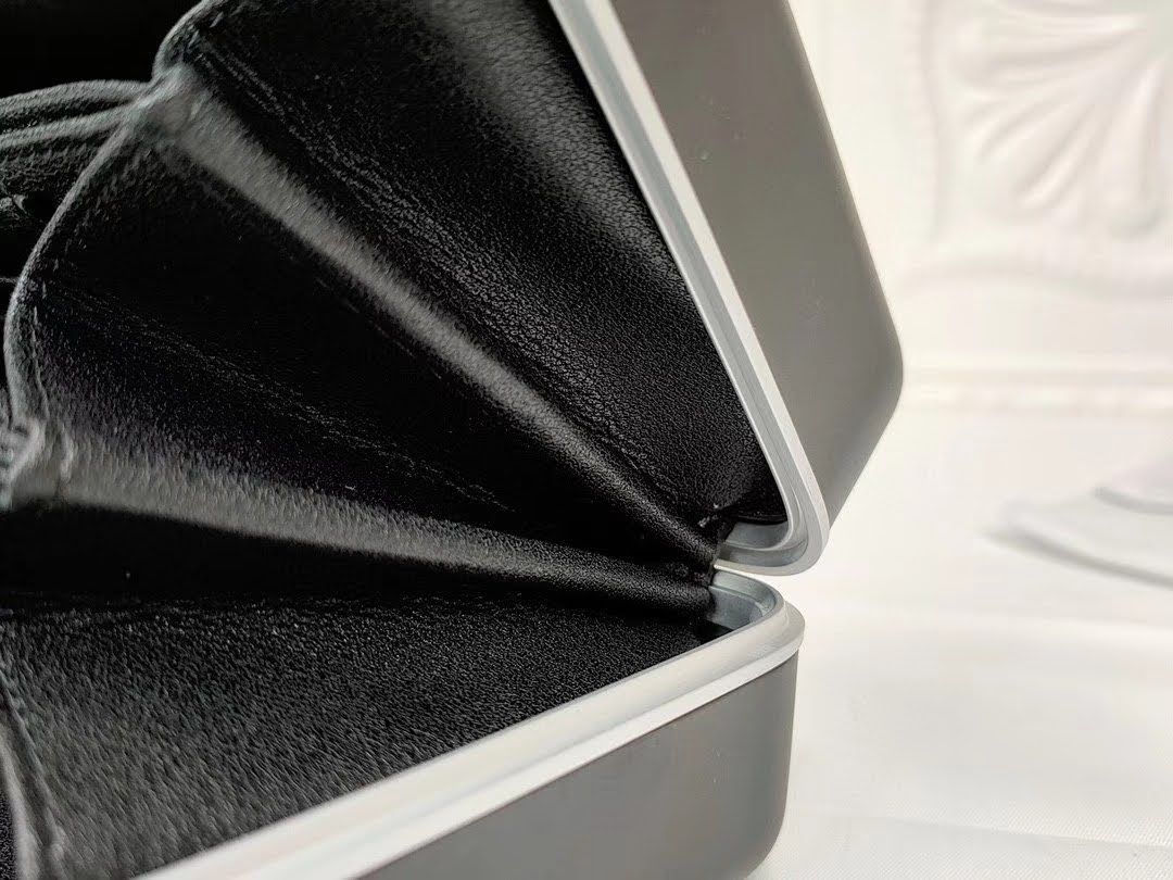 Presentation image of the gray Dior x Rimowa aluminum clutch opening detail