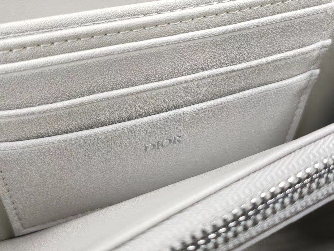 Presentation image of the gray Dior x Rimowa aluminum clutch integrated card holder interior